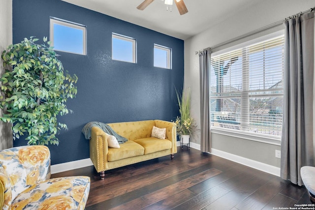 sitting room with a ceiling fan, baseboards, and hardwood / wood-style flooring