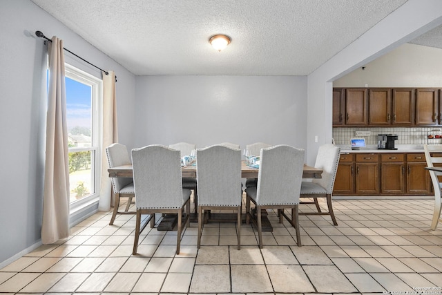 dining space with light tile patterned floors and a textured ceiling