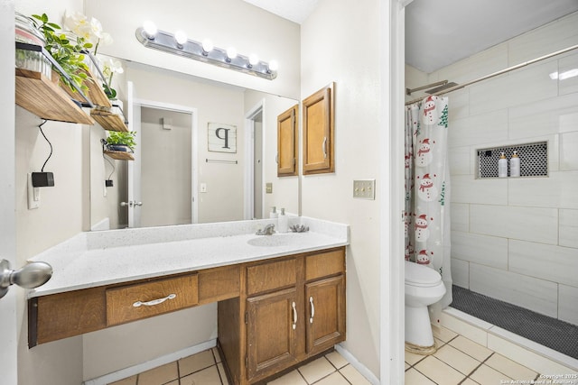 full bathroom featuring toilet, tile patterned flooring, tiled shower, and vanity