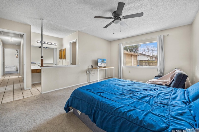 bedroom with light carpet, attic access, baseboards, connected bathroom, and a textured ceiling