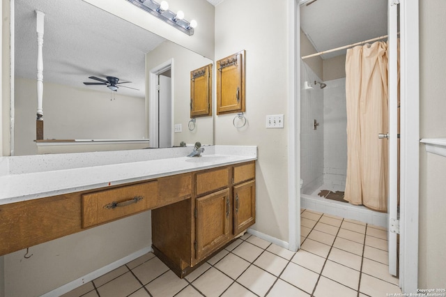 bathroom with a stall shower, ceiling fan, vanity, and tile patterned floors