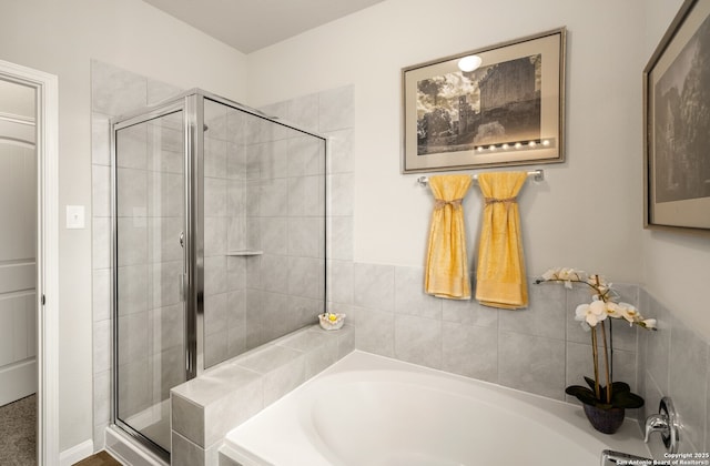 full bath featuring a garden tub and a shower stall