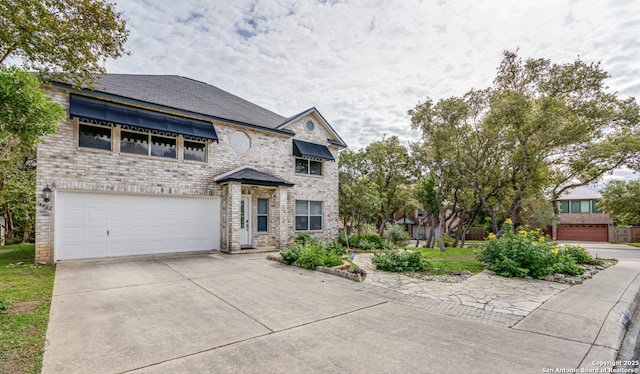 view of front facade with driveway, brick siding, and an attached garage