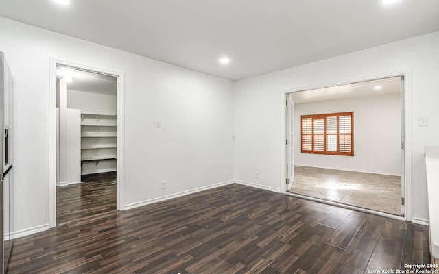 spare room with recessed lighting, baseboards, and wood finished floors