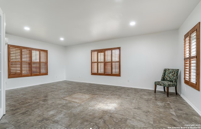 empty room with baseboards, recessed lighting, and a healthy amount of sunlight