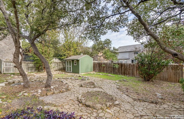 view of yard with a storage shed, a fenced backyard, and an outdoor structure