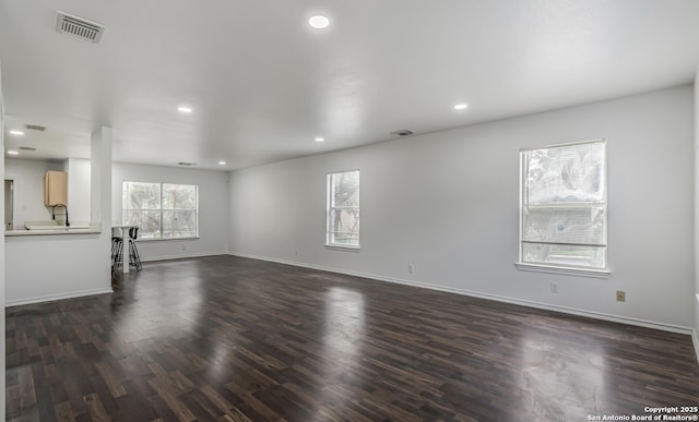 unfurnished living room with dark wood-style floors, recessed lighting, visible vents, and baseboards