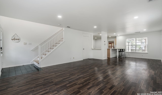 unfurnished living room featuring stairs, visible vents, wood finished floors, and recessed lighting