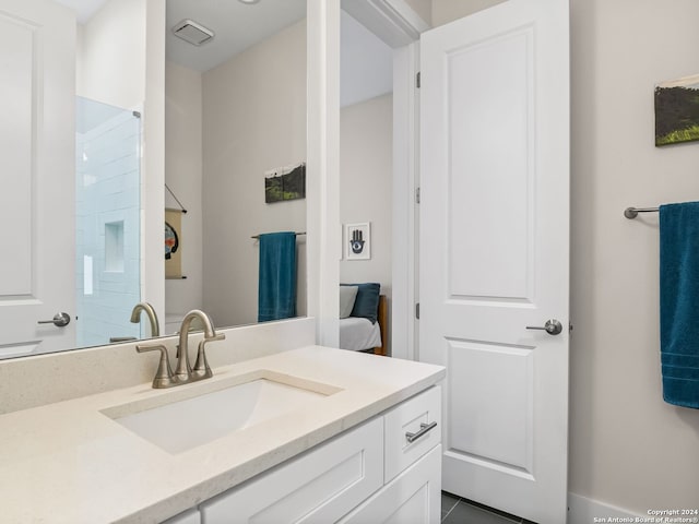 bathroom with visible vents, walk in shower, and vanity