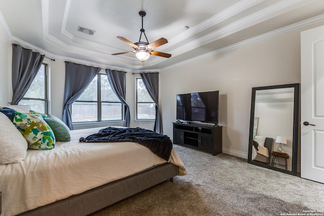 carpeted bedroom with a raised ceiling, visible vents, crown molding, and ceiling fan