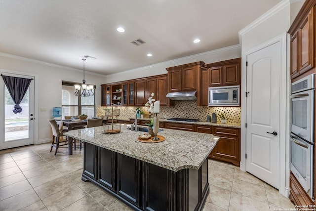 kitchen with visible vents, decorative backsplash, appliances with stainless steel finishes, a sink, and under cabinet range hood