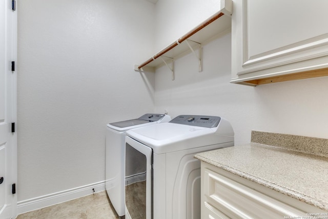 laundry room featuring cabinet space, baseboards, and separate washer and dryer