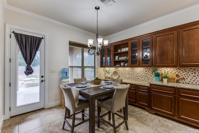 dining room with light tile patterned floors, visible vents, ornamental molding, a chandelier, and baseboards