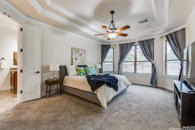 carpeted bedroom with a tray ceiling, visible vents, and multiple windows