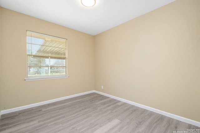 empty room featuring light wood-style floors and baseboards