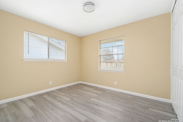 spare room featuring light wood-style flooring and baseboards