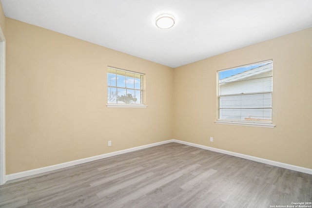 empty room with baseboards and wood finished floors