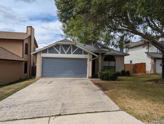 view of front of house featuring a garage, driveway, fence, a front lawn, and brick siding