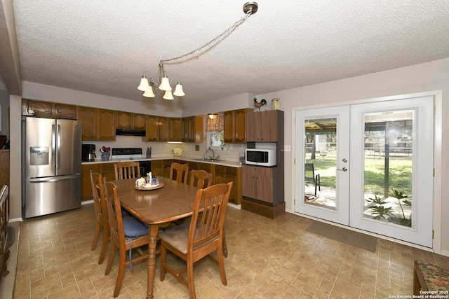 dining space with a textured ceiling and french doors