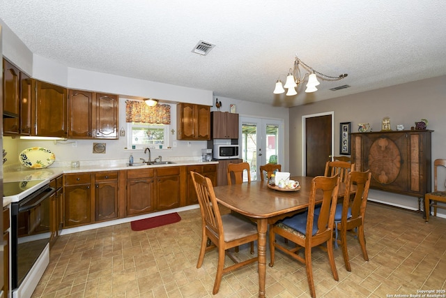 dining area featuring a chandelier, a wealth of natural light, french doors, and visible vents