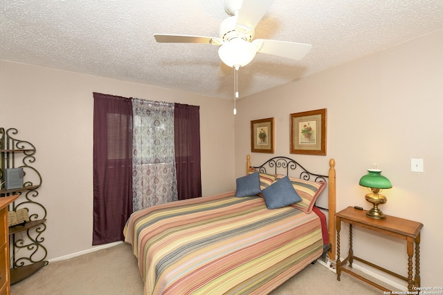 bedroom with a ceiling fan, light carpet, a textured ceiling, and baseboards