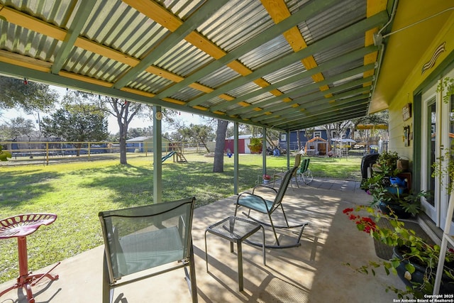 view of patio with playground community and a fenced backyard