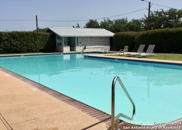 pool with a patio area and an outdoor structure