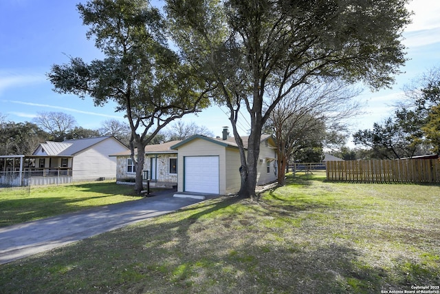 view of front facade featuring a garage, fence, driveway, and a front lawn