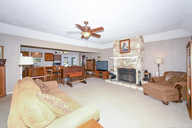 living room with a fireplace, a ceiling fan, a textured ceiling, and carpet flooring