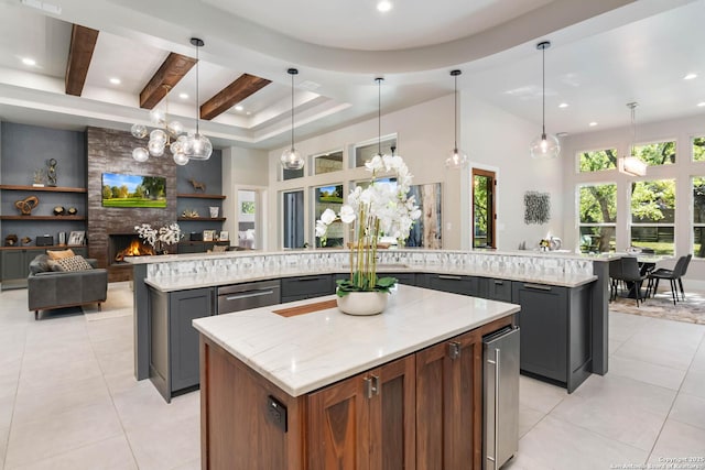 kitchen featuring a spacious island, plenty of natural light, a fireplace, and light tile patterned flooring