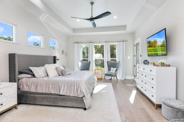 bedroom featuring a tray ceiling, access to outside, recessed lighting, a ceiling fan, and light wood-type flooring