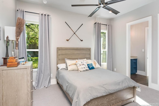 carpeted bedroom with ceiling fan and baseboards