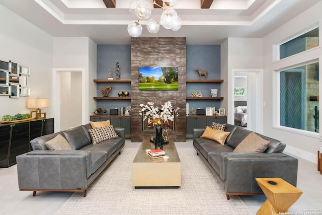 living area with baseboards, built in features, a raised ceiling, an inviting chandelier, and a fireplace