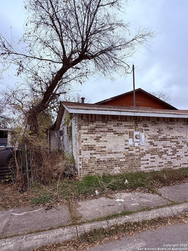 view of side of home with brick siding