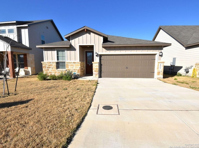 view of front of property featuring a garage, driveway, stone siding, a front lawn, and board and batten siding