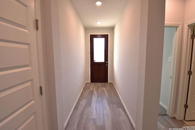 doorway to outside with light wood-style floors and baseboards