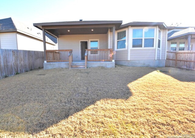 back of house featuring a porch, a yard, and fence