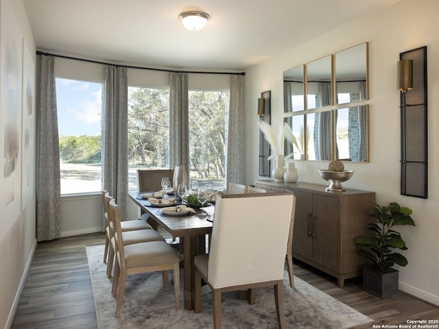 dining area with light wood-style floors, a wealth of natural light, and baseboards