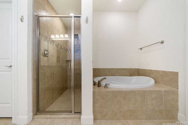 bathroom featuring a stall shower, a bath, and tile patterned floors