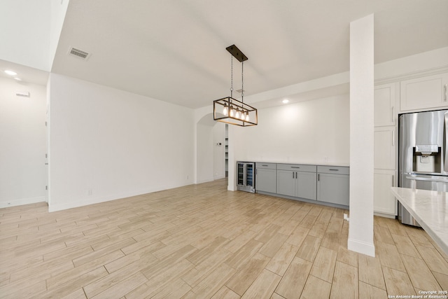 interior space with recessed lighting, beverage cooler, visible vents, wood tiled floor, and a bar