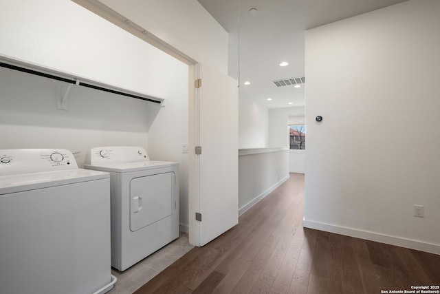 washroom with laundry area, visible vents, baseboards, light wood-style flooring, and washing machine and clothes dryer