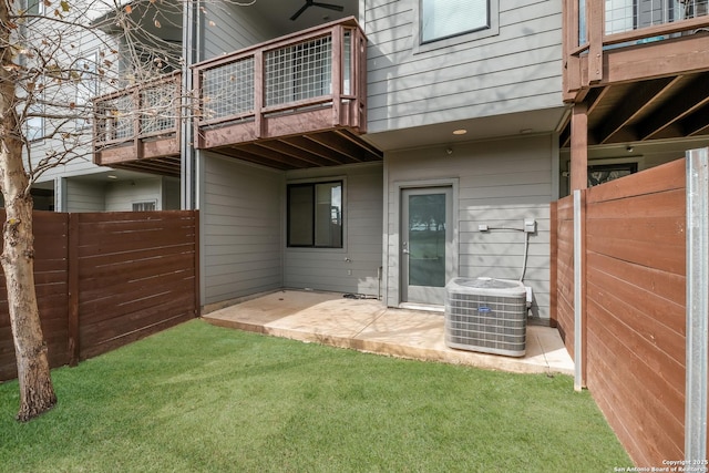 back of property featuring a balcony, central air condition unit, fence, a yard, and a patio area