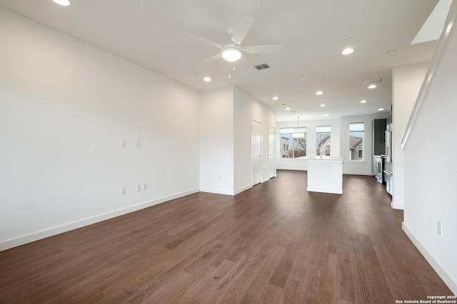 unfurnished living room with baseboards, visible vents, dark wood-type flooring, and recessed lighting