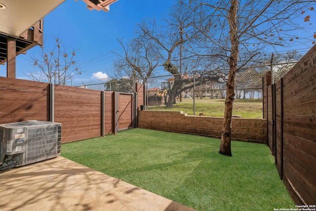 view of yard with central AC and a fenced backyard