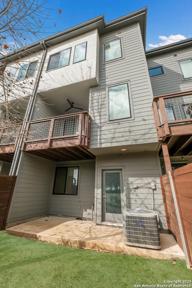 rear view of property with cooling unit, a patio, and a balcony