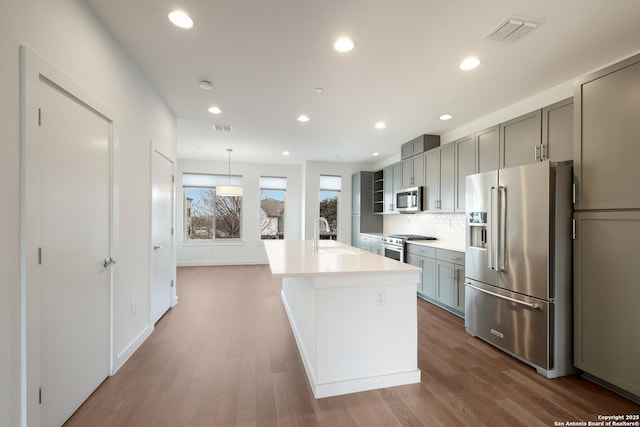 kitchen with high quality appliances, visible vents, and gray cabinets