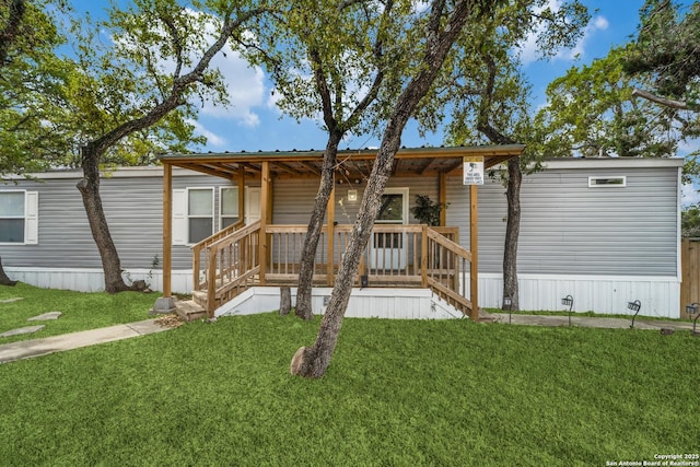 view of front of property with a front yard, covered porch, and metal roof