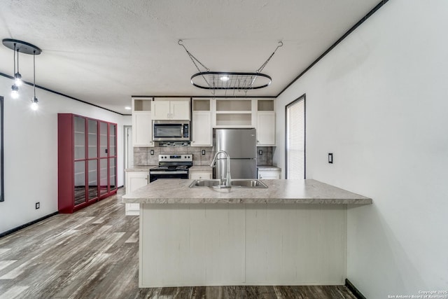 kitchen featuring white cabinets, decorative backsplash, dark wood-type flooring, stainless steel appliances, and a sink