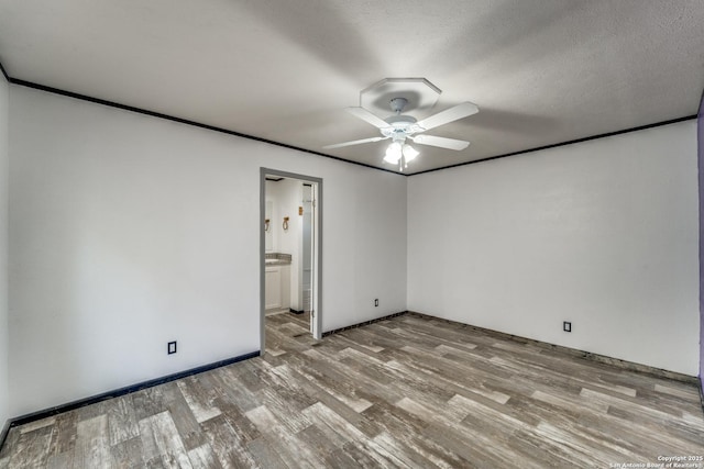 spare room with ceiling fan, ornamental molding, and wood finished floors