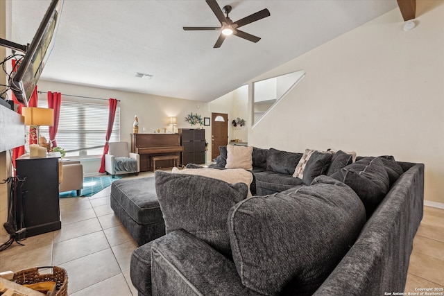 living room featuring ceiling fan, visible vents, vaulted ceiling, and light tile patterned flooring